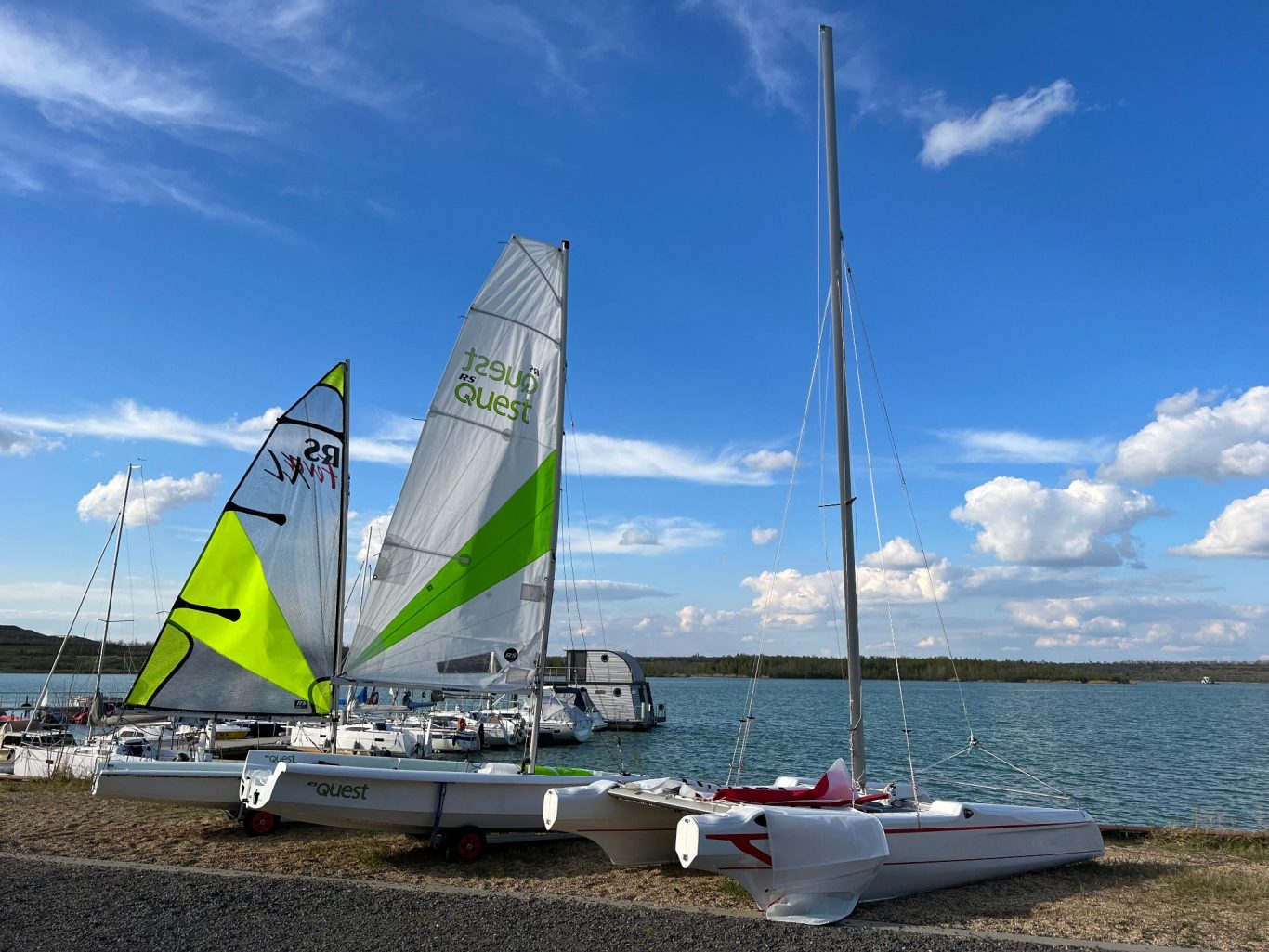 Segeljollen und Katamaran der Segelschule Sweet Water Adventures am Ufer vom Störmthaler See