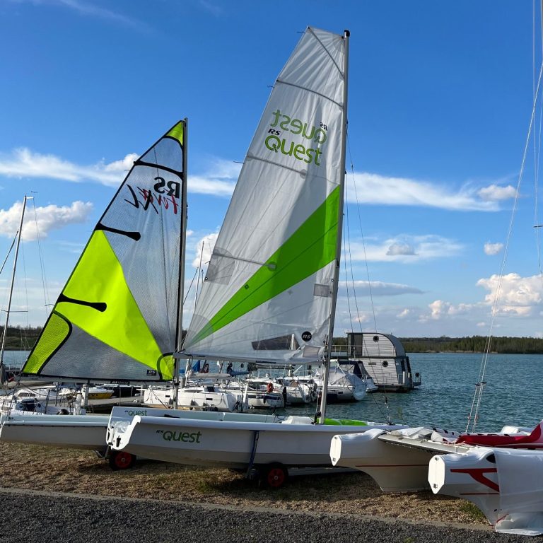 Segeljollen und Katamaran am Ufer des Störmthaler Sees